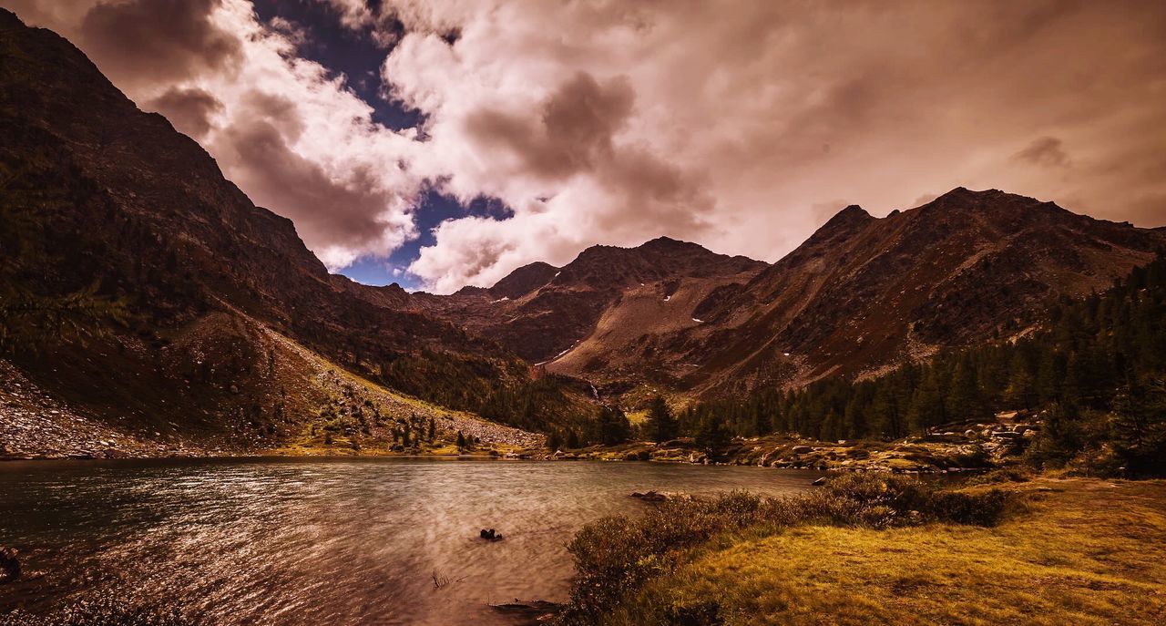 Scenic view of lake by mountains against sky