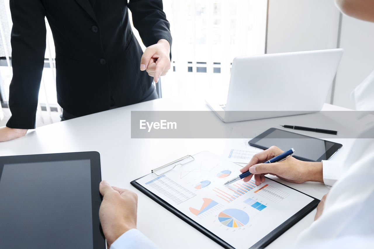 PEOPLE WORKING ON TABLE IN OFFICE