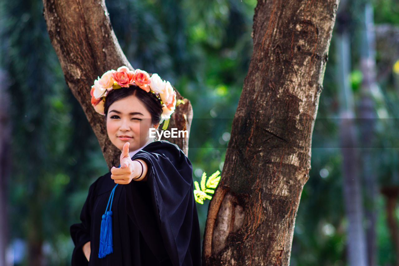 Portrait of young woman standing in forest