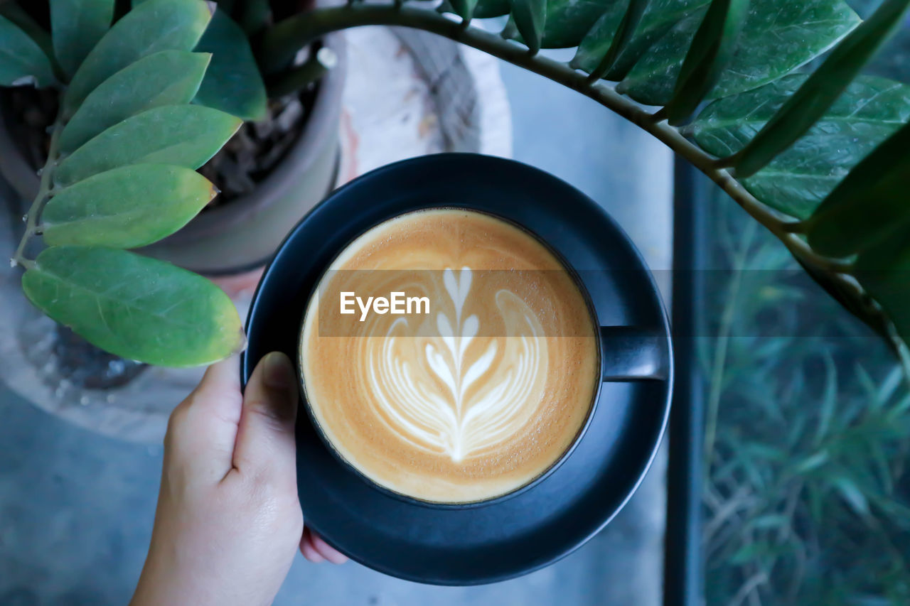 Close-up of hand holding coffee cup