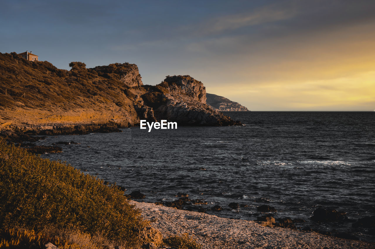 SCENIC VIEW OF ROCKS ON SEA AGAINST SKY