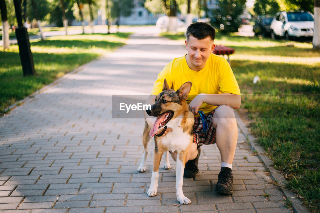 Full length of man with dog on footpath