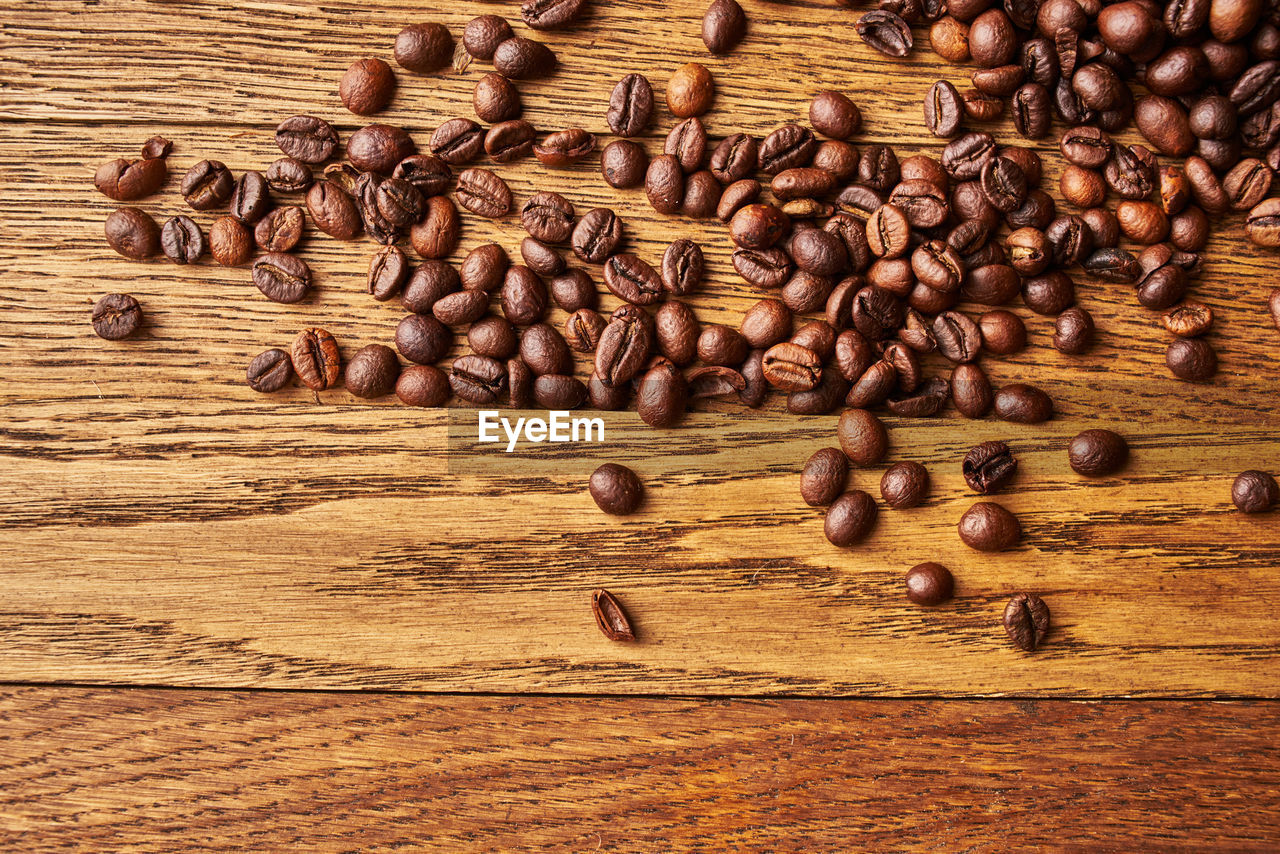 HIGH ANGLE VIEW OF COFFEE BEANS ON WOODEN TABLE