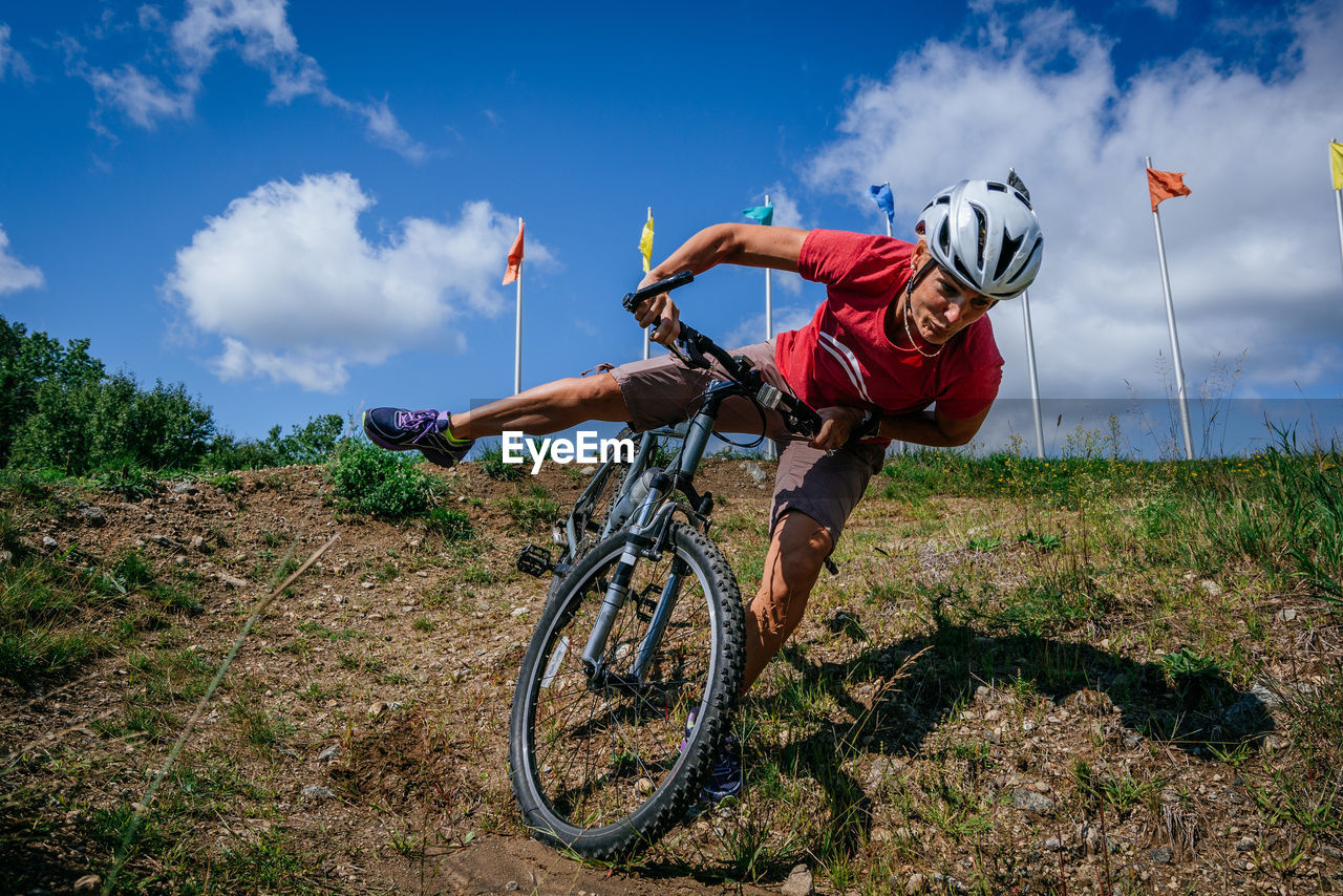 Man cycling on bicycle against sky