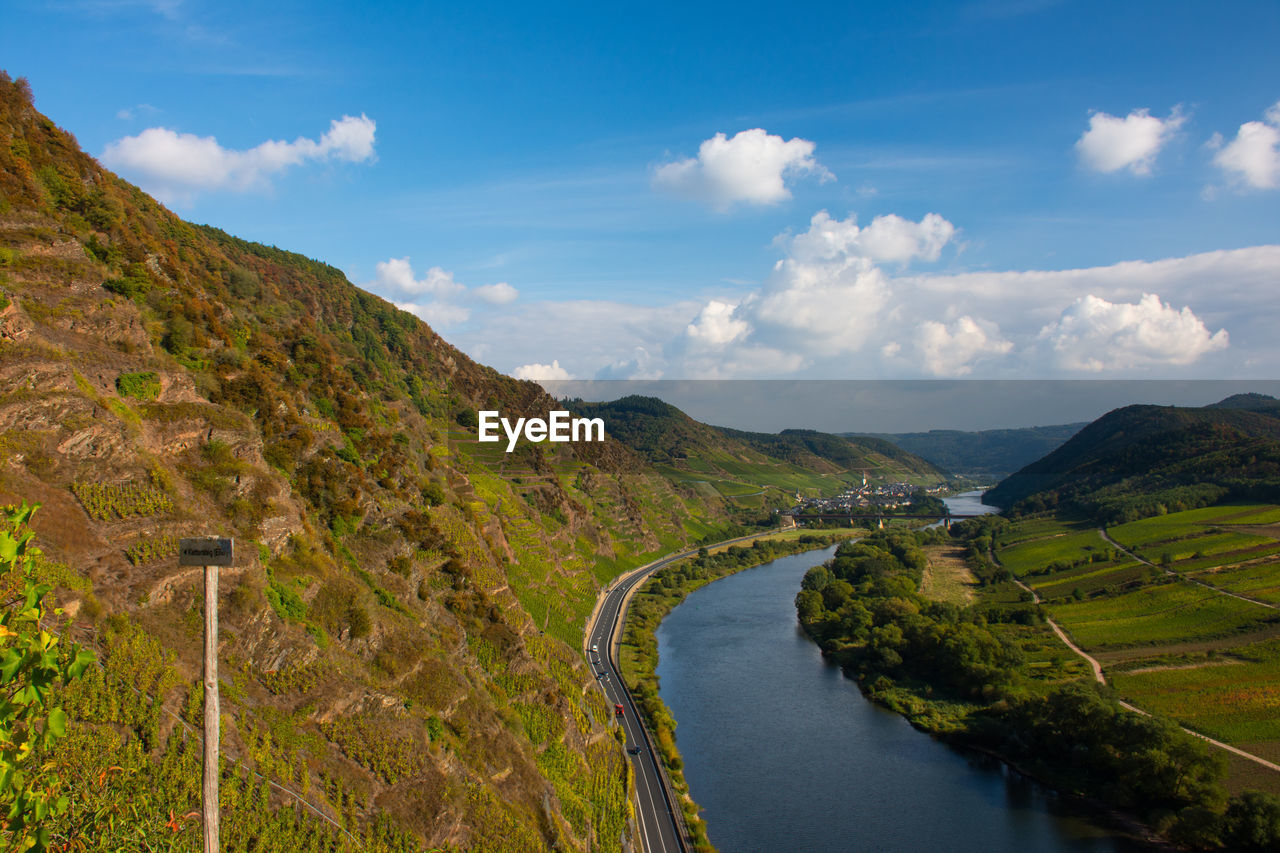 Scenic view of river by mountains against sky