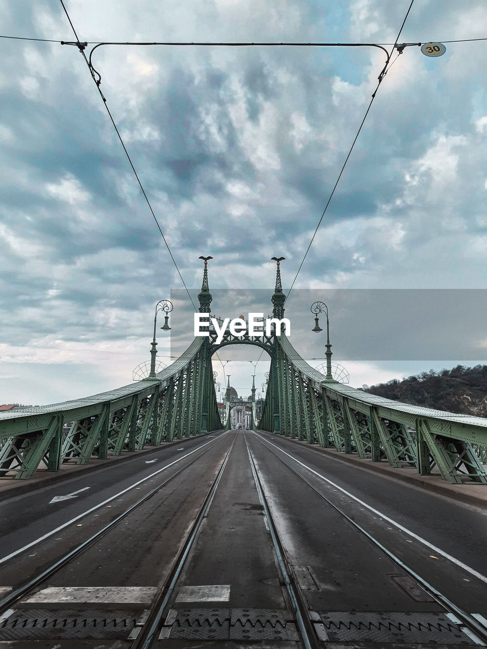 View of railroad tracks on bridge against cloudy sky