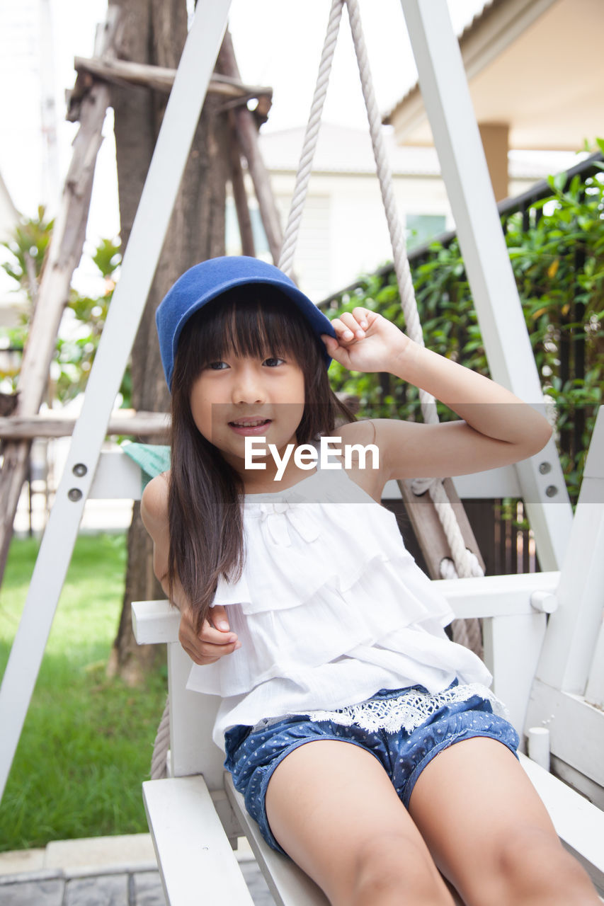 Portrait of girl sitting on swing