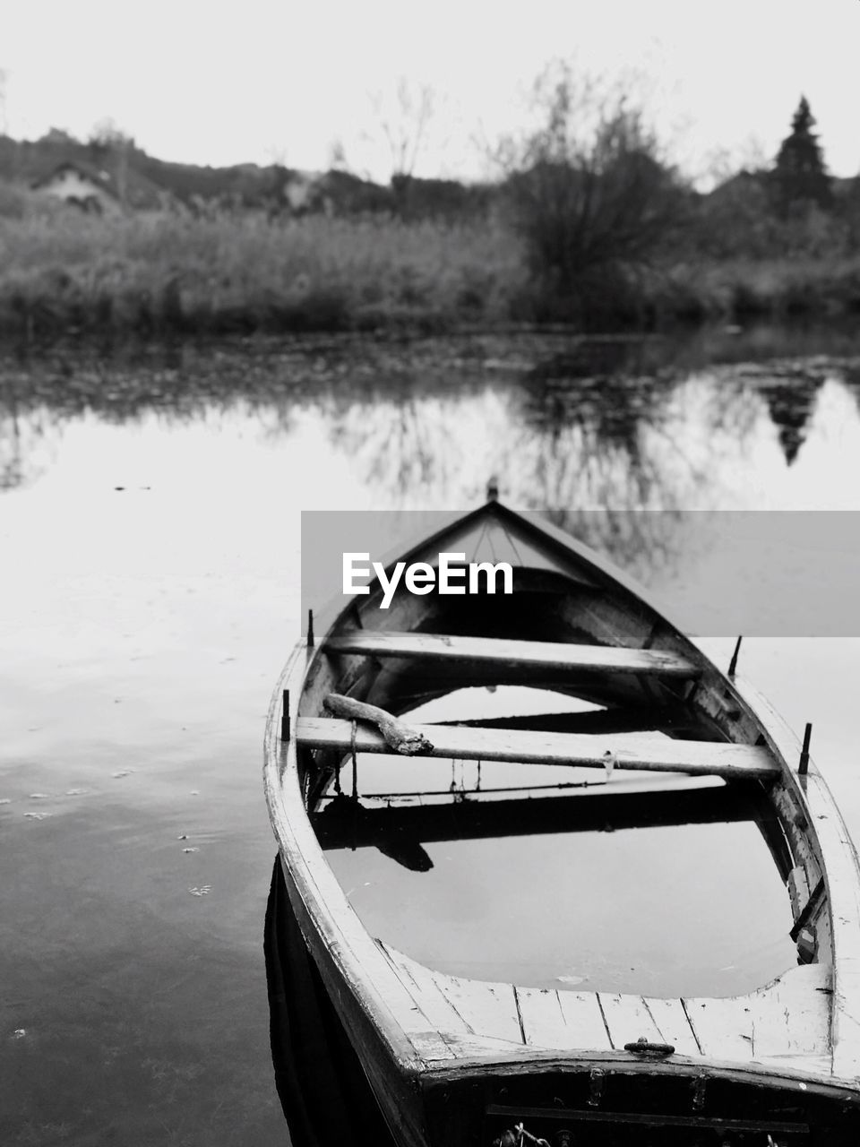 Boat moored in lake against sky