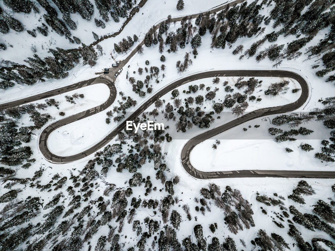 High angle view of winding road amidst snow covered land