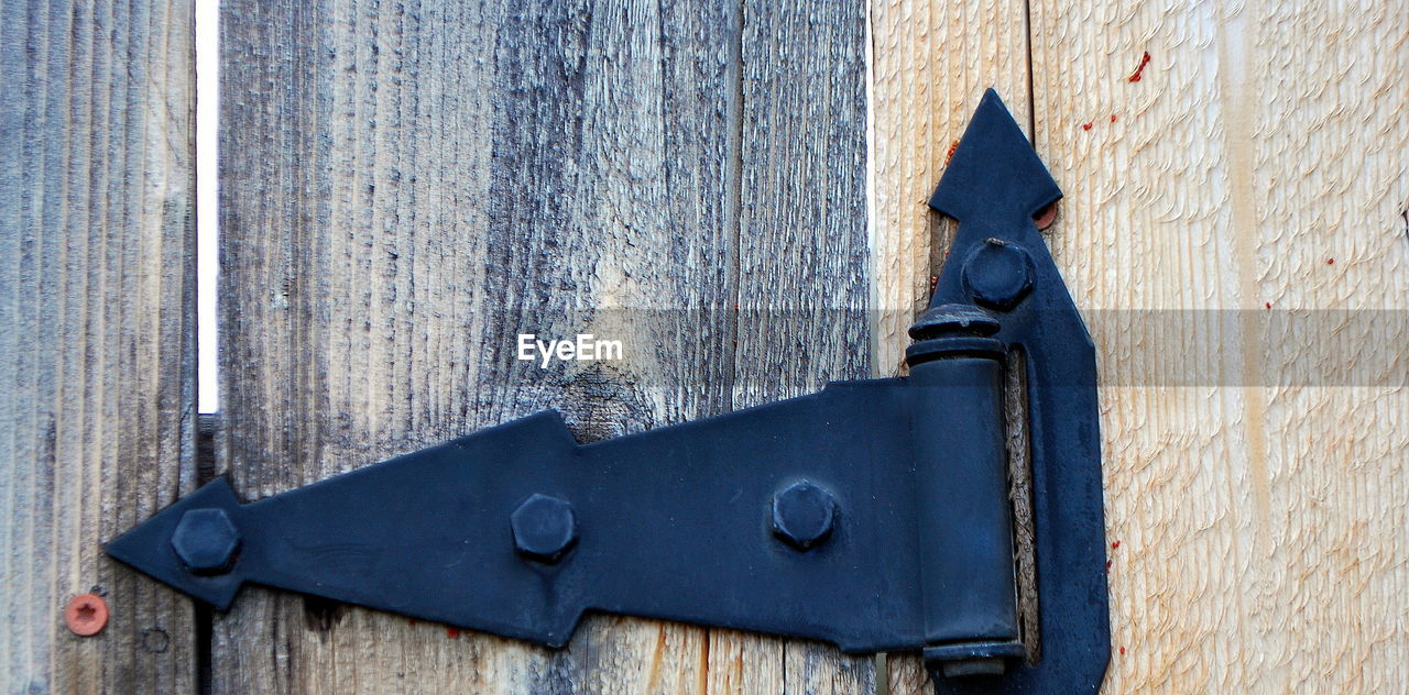 LOW ANGLE VIEW OF OLD METAL DOOR ON WEATHERED WALL