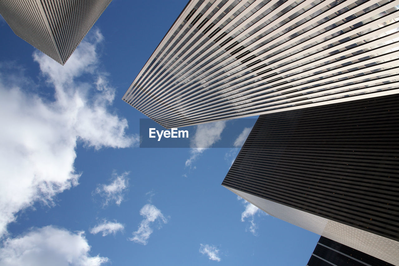 Low angle view of modern building against cloudy sky