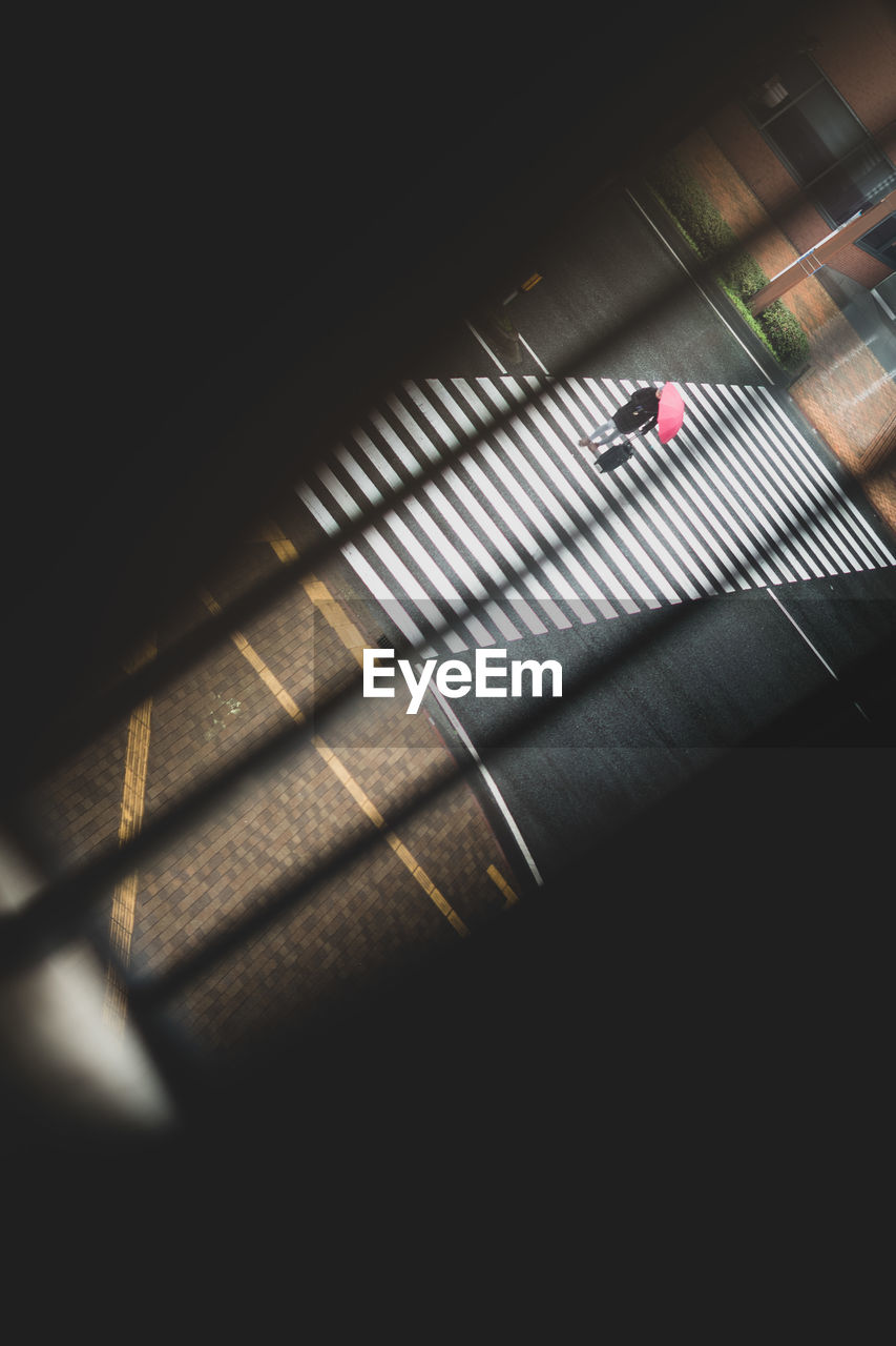 High angle view of person walking on zebra crossing in city