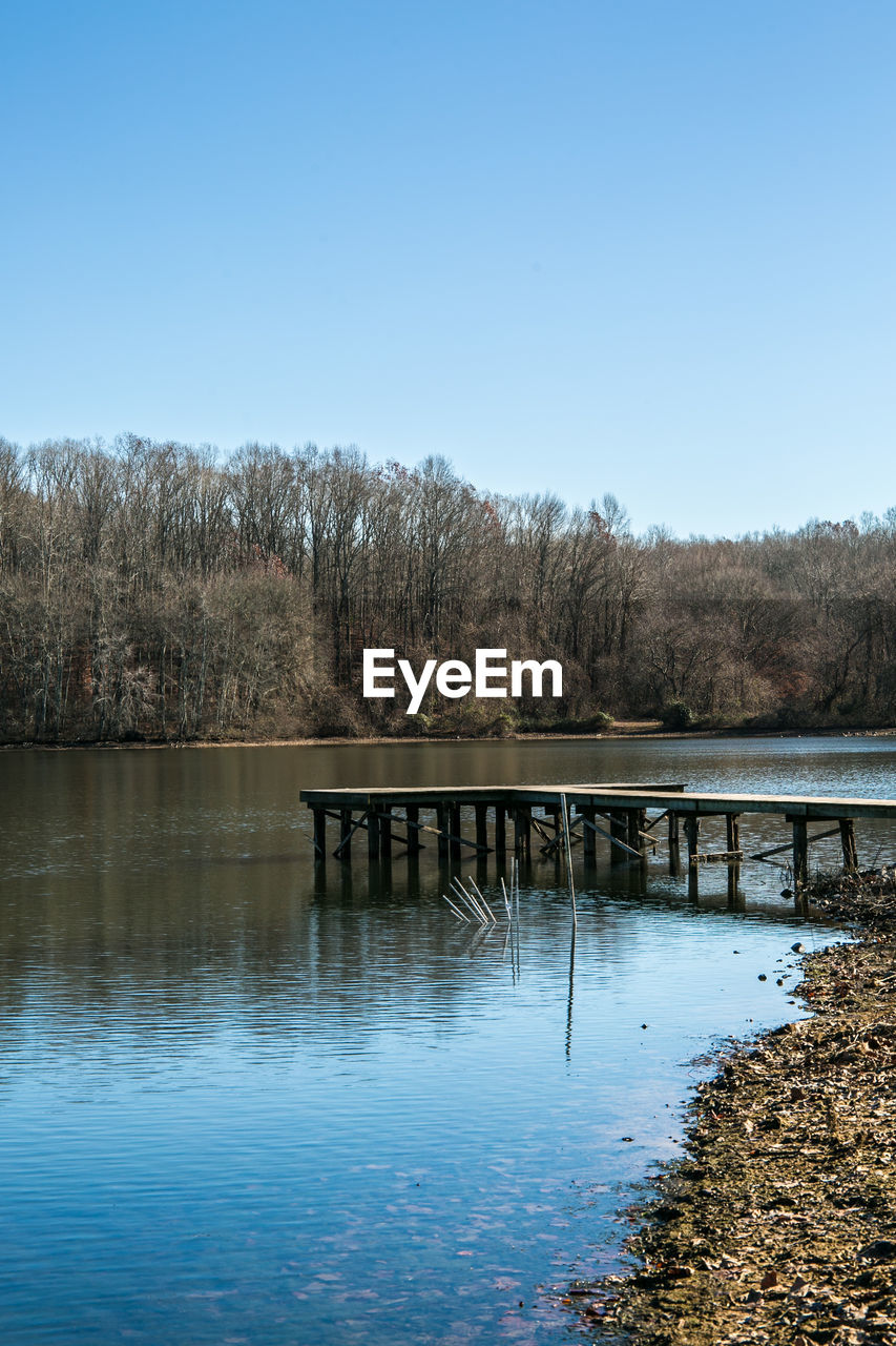 Pier over lake against clear sky