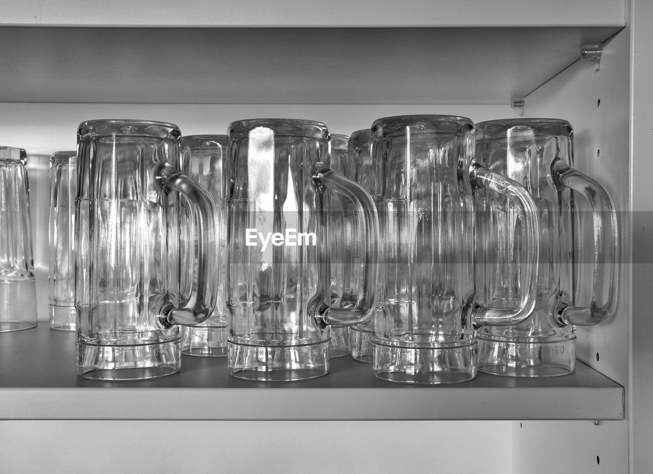 Jugs arranged on shelf in kitchen