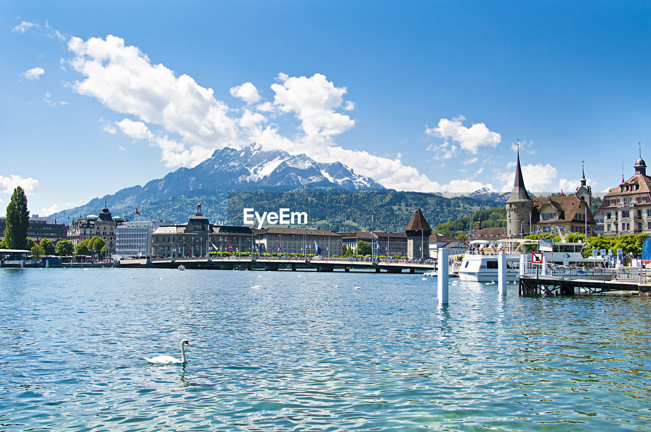 Scenic view of river by buildings against sky