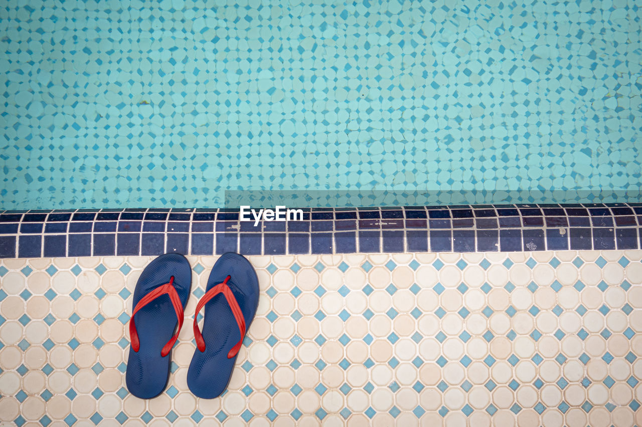 blue, shoe, swimming pool, footwear, sandal, red, tile, flooring, water, flip-flops, high angle view, day, pair, low section, pattern, nature, human leg, outdoors, absence, directly above, poolside, azure, fashion, turquoise, tiled floor, green