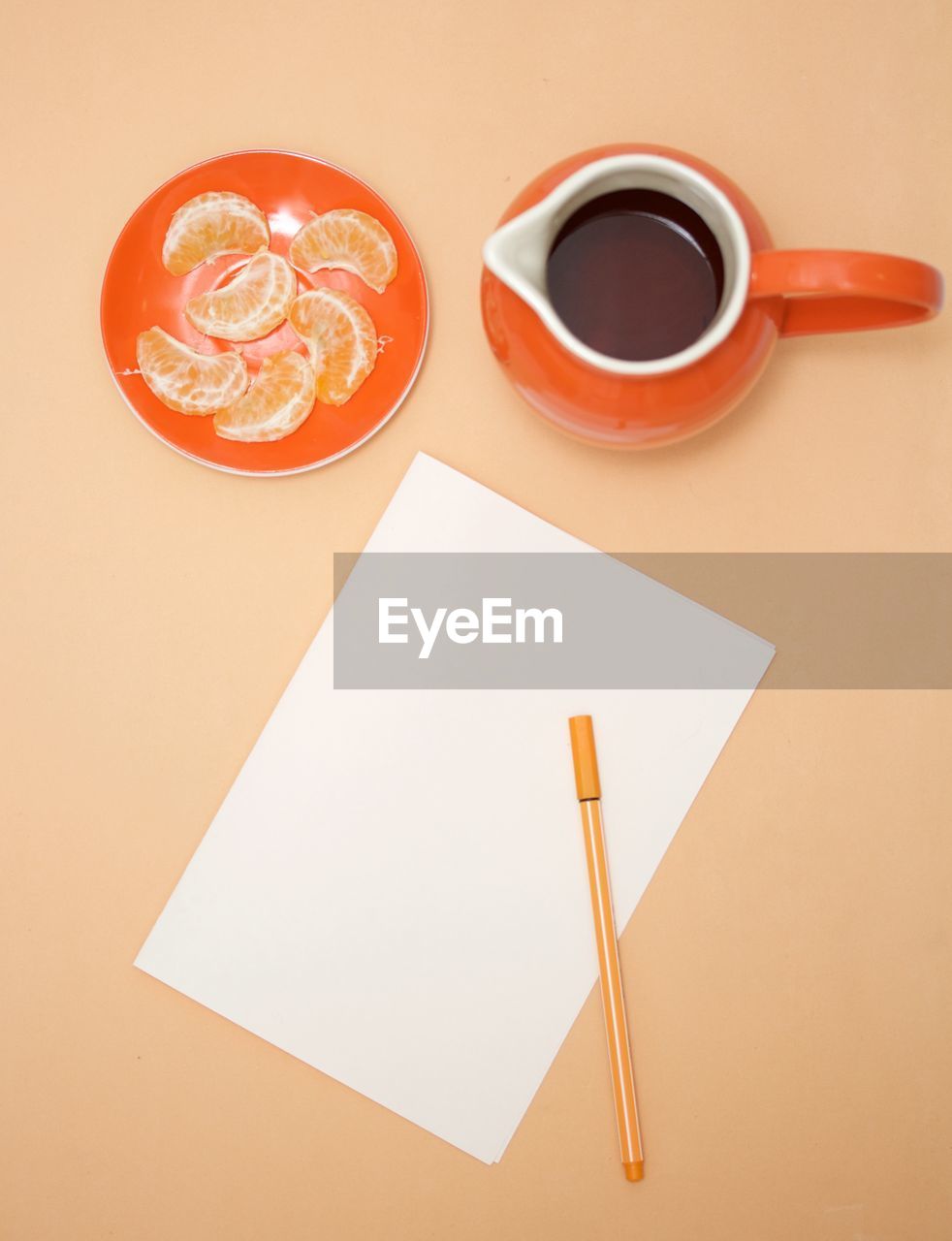 Directly above view of coffee with orange fruit and blank paper