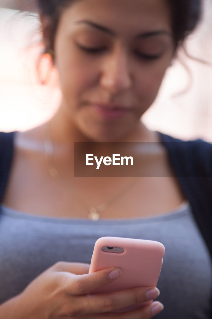 Close-up of young woman using mobile phone