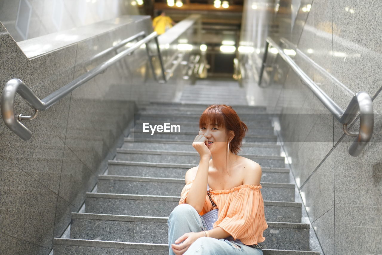 WOMAN SITTING ON STAIRCASE