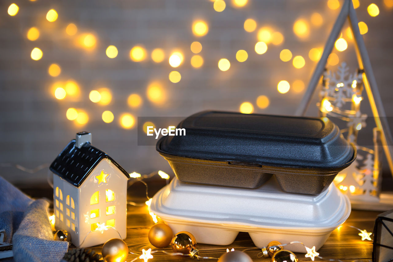 CLOSE-UP OF ILLUMINATED CHRISTMAS DECORATION ON TABLE