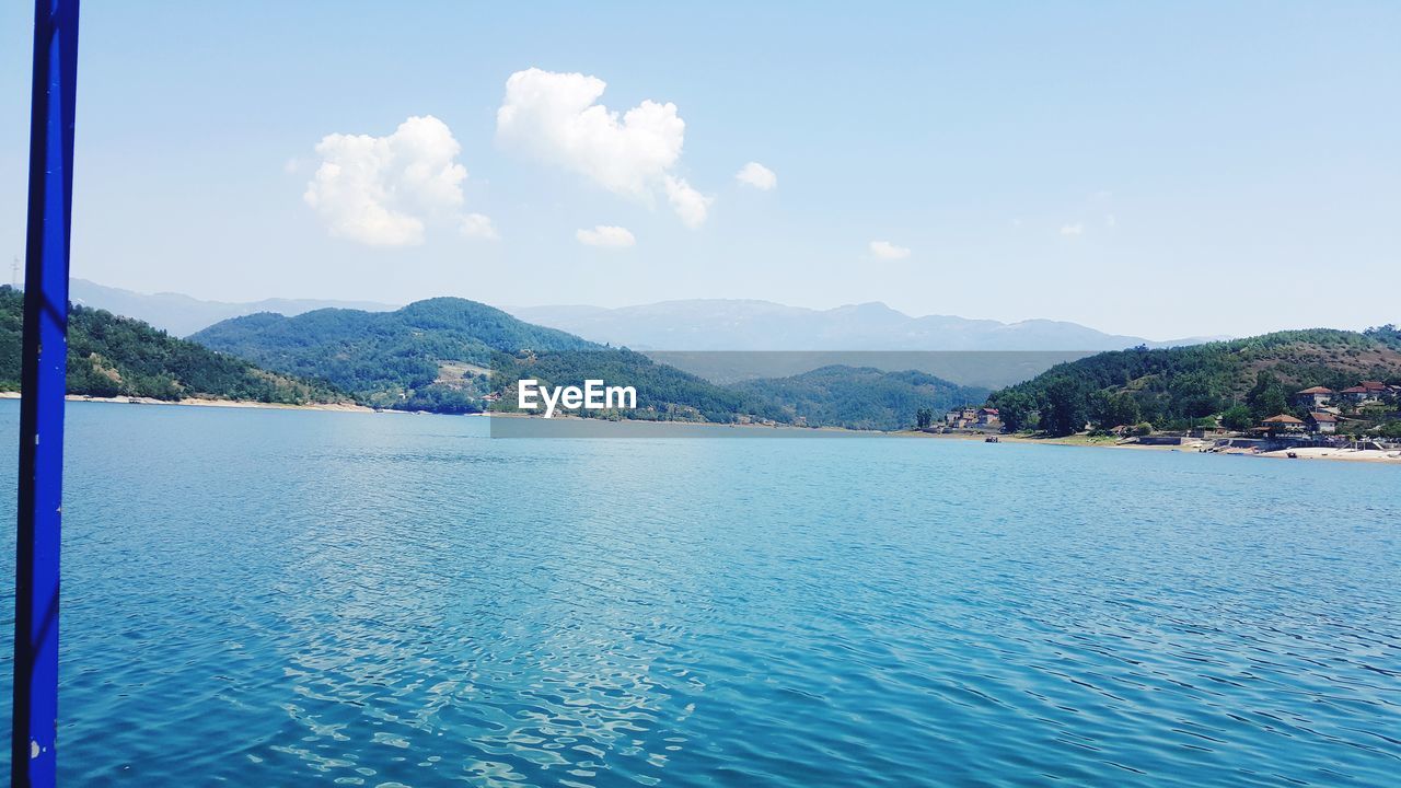 Scenic view of sea and mountains against sky