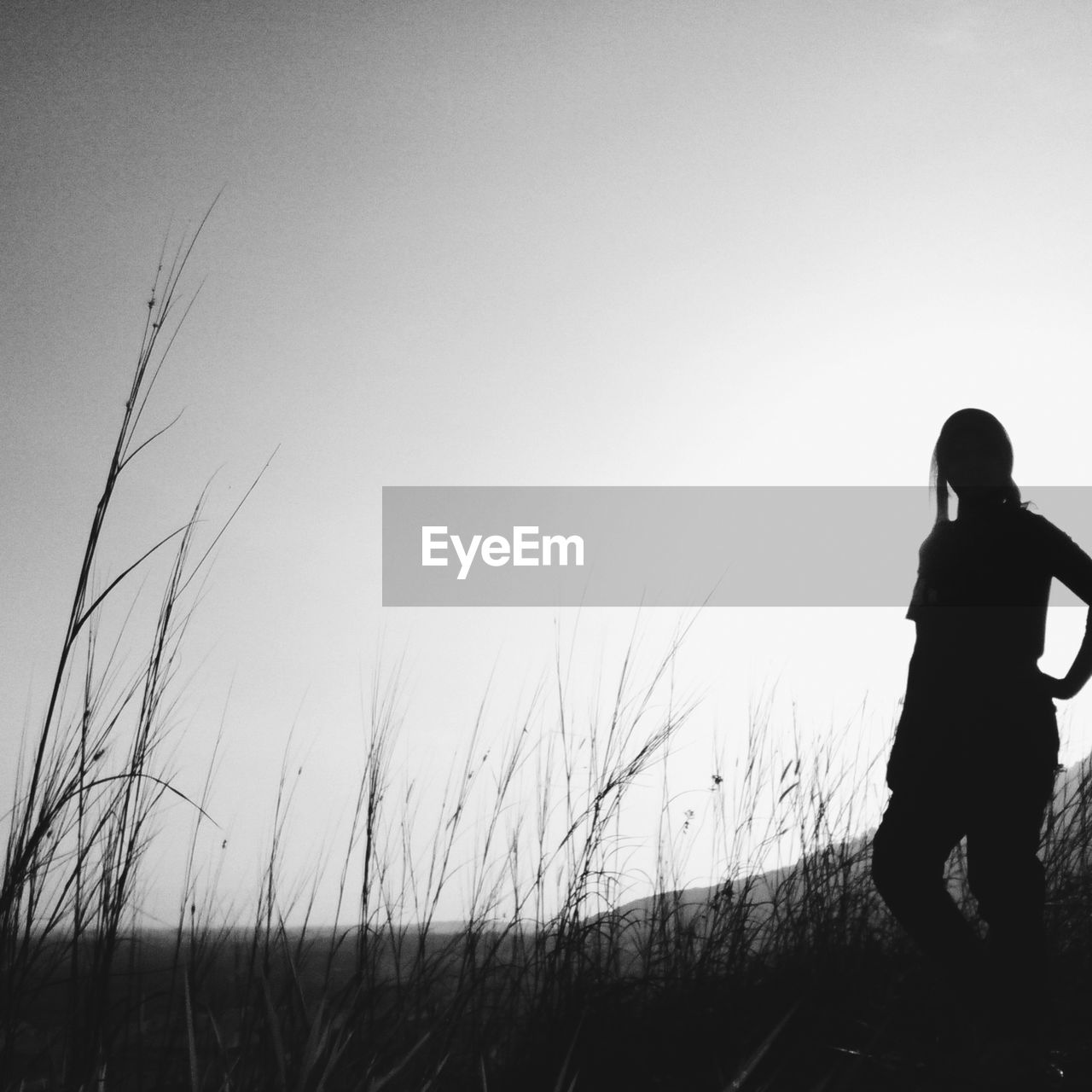 Woman standing on grassy field against sky