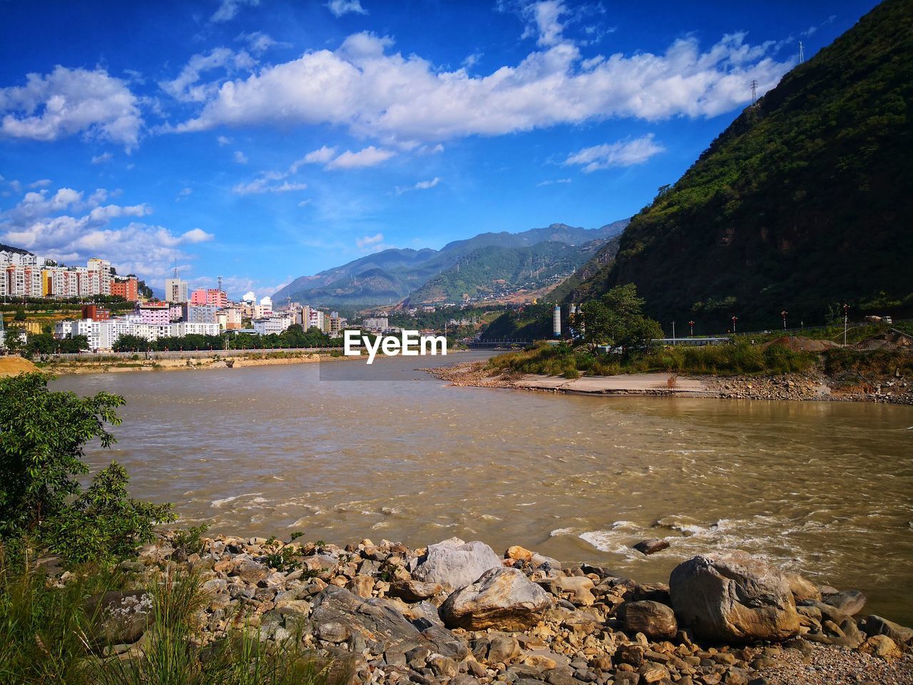 RIVER AMIDST BUILDINGS AGAINST SKY