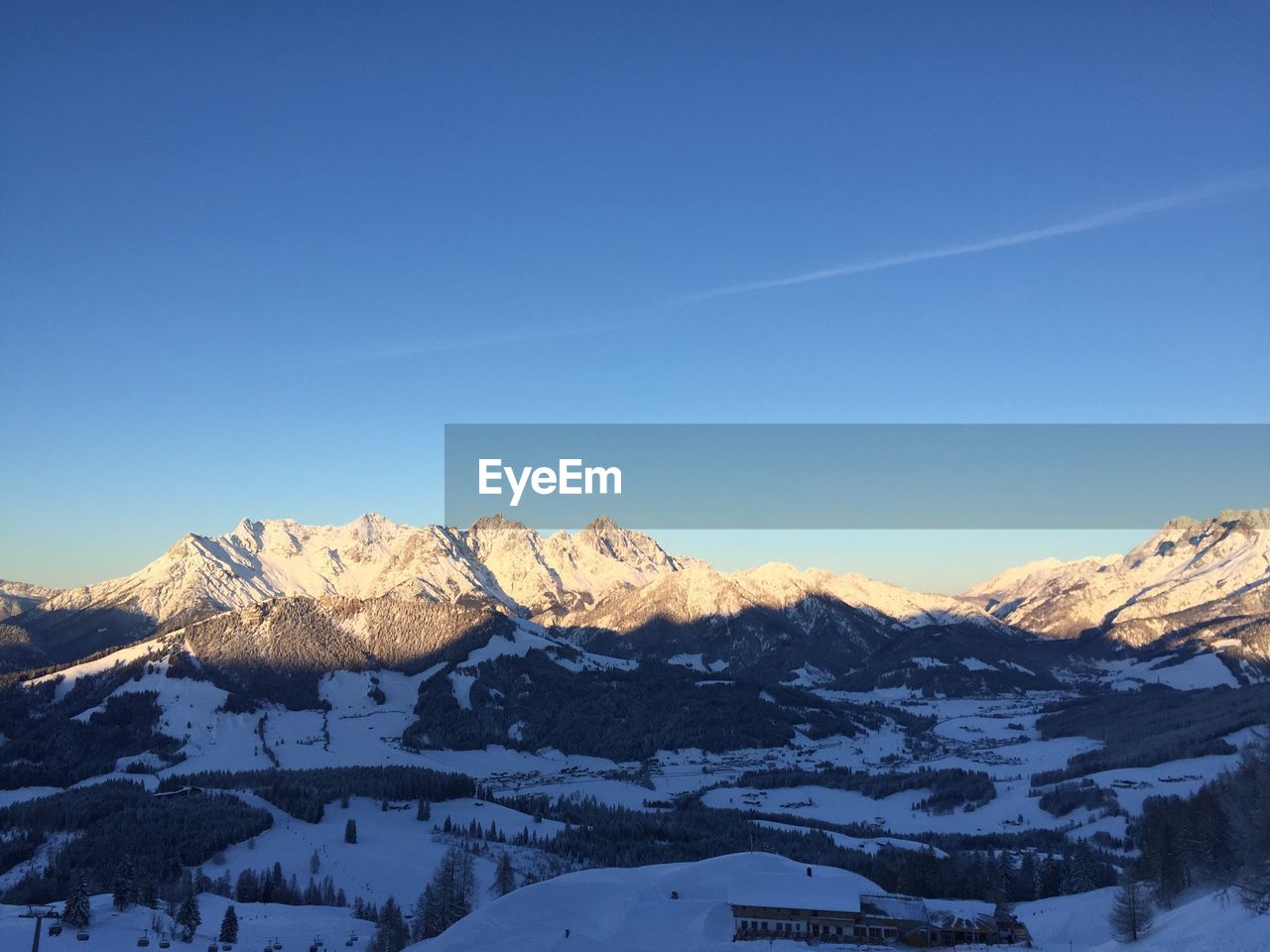 Scenic view of snowcapped mountains against blue sky