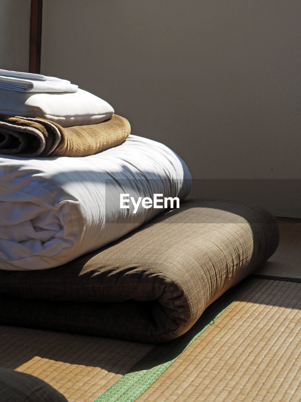 Sunlight falling on futon over tatami mat at home