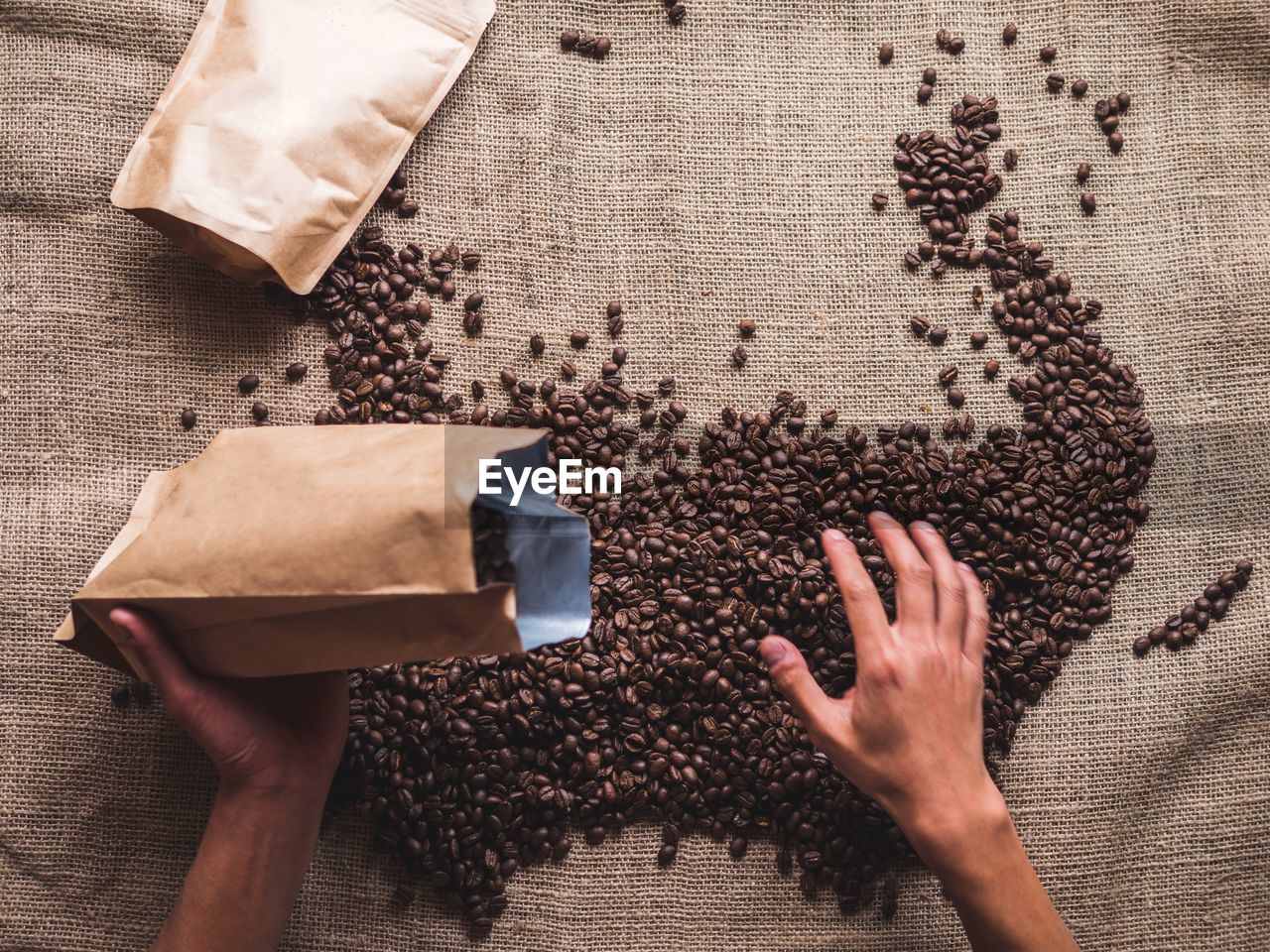 Cropped hand pouring coffee beans in package