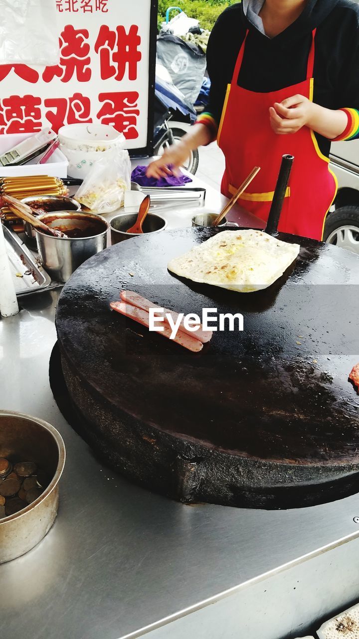 MIDSECTION OF MAN PREPARING FOOD