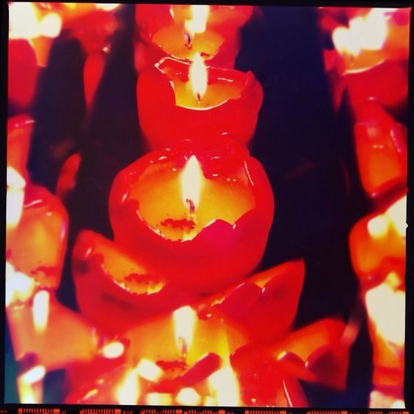CLOSE-UP OF CANDLES IN DARK ROOM