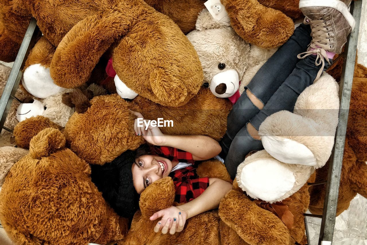 High angle view of woman amidst stuffed toys 