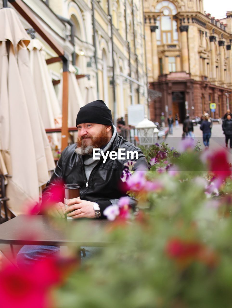 Man having drink while sitting at sidewalk cafe