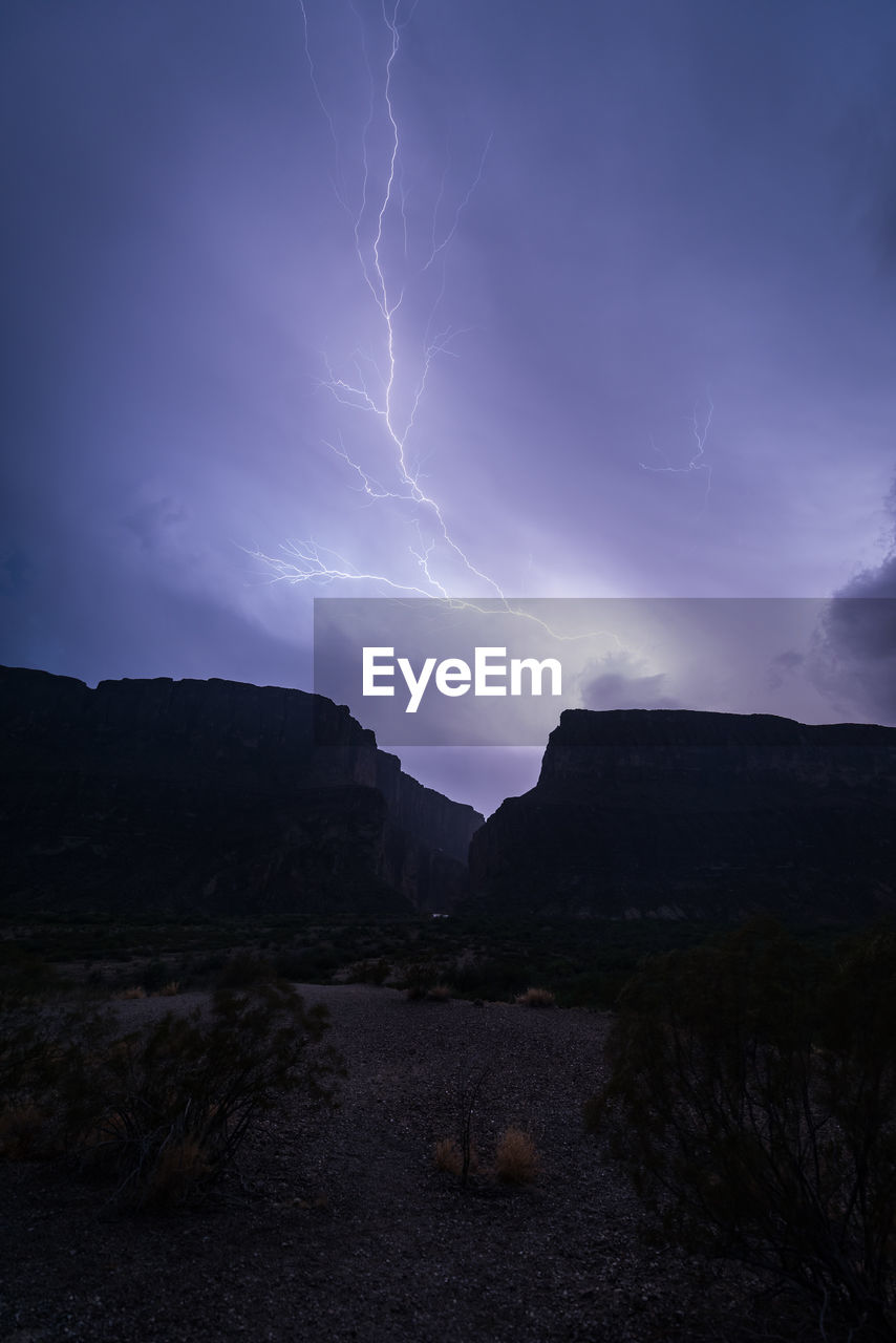 SCENIC VIEW OF LIGHTNING OVER MOUNTAINS