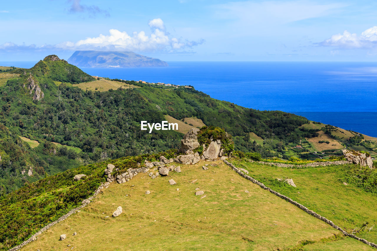 Scenic view of sea and mountains against sky