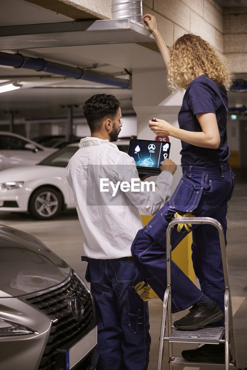 Man and woman checking air duct