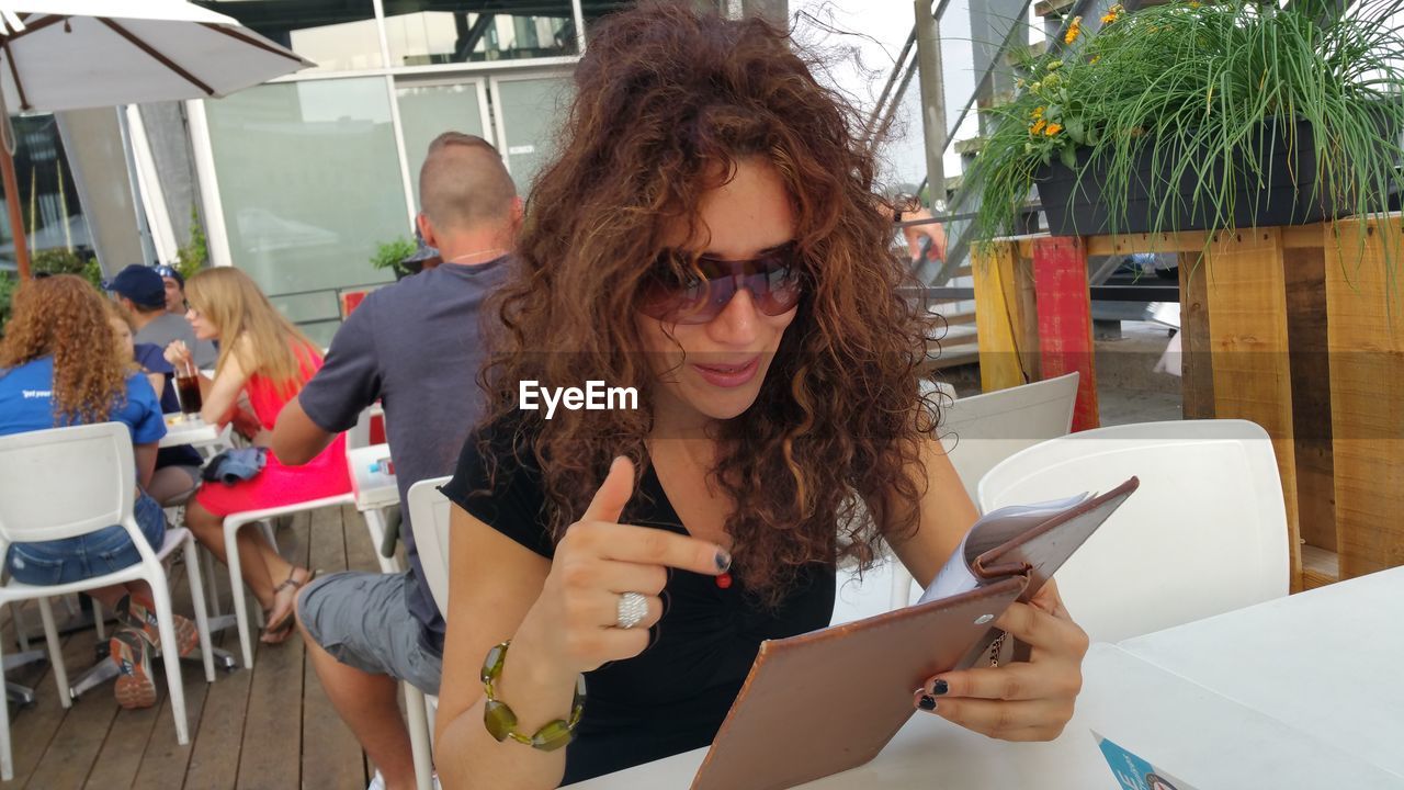 Woman looking at menu while sitting in restaurant