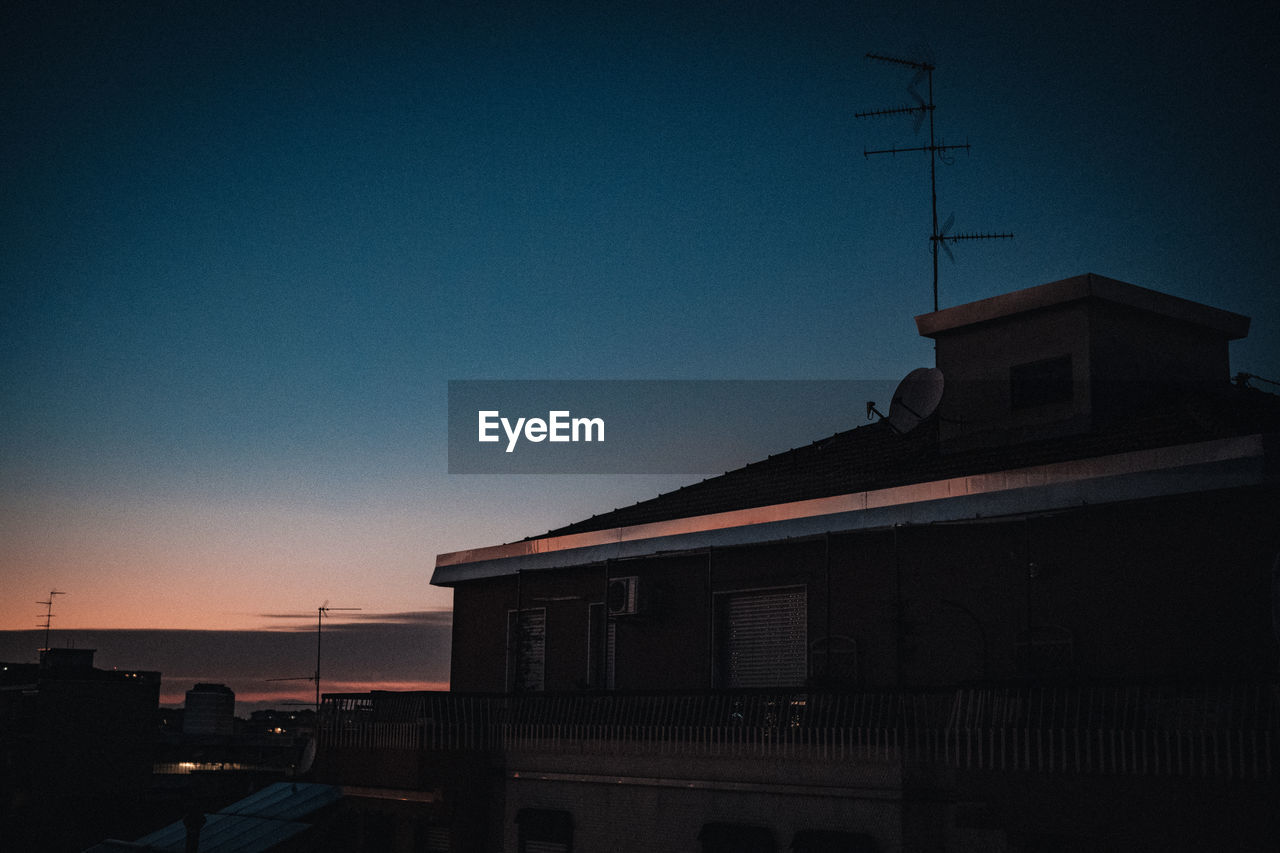 SILHOUETTE BUILDINGS AGAINST CLEAR SKY DURING SUNSET