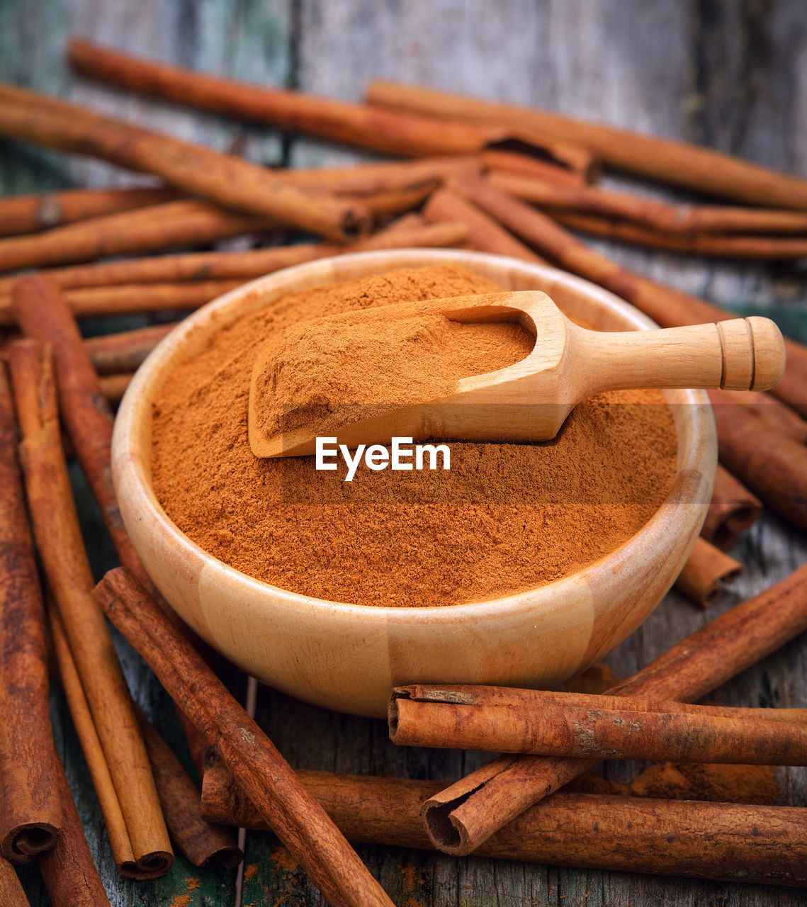 Close-up of cinnamons with grounded spice on table