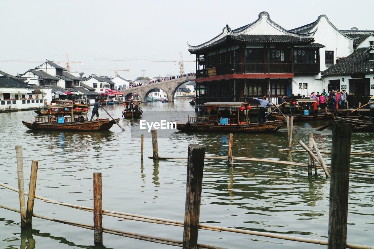 People oaring boat in river
