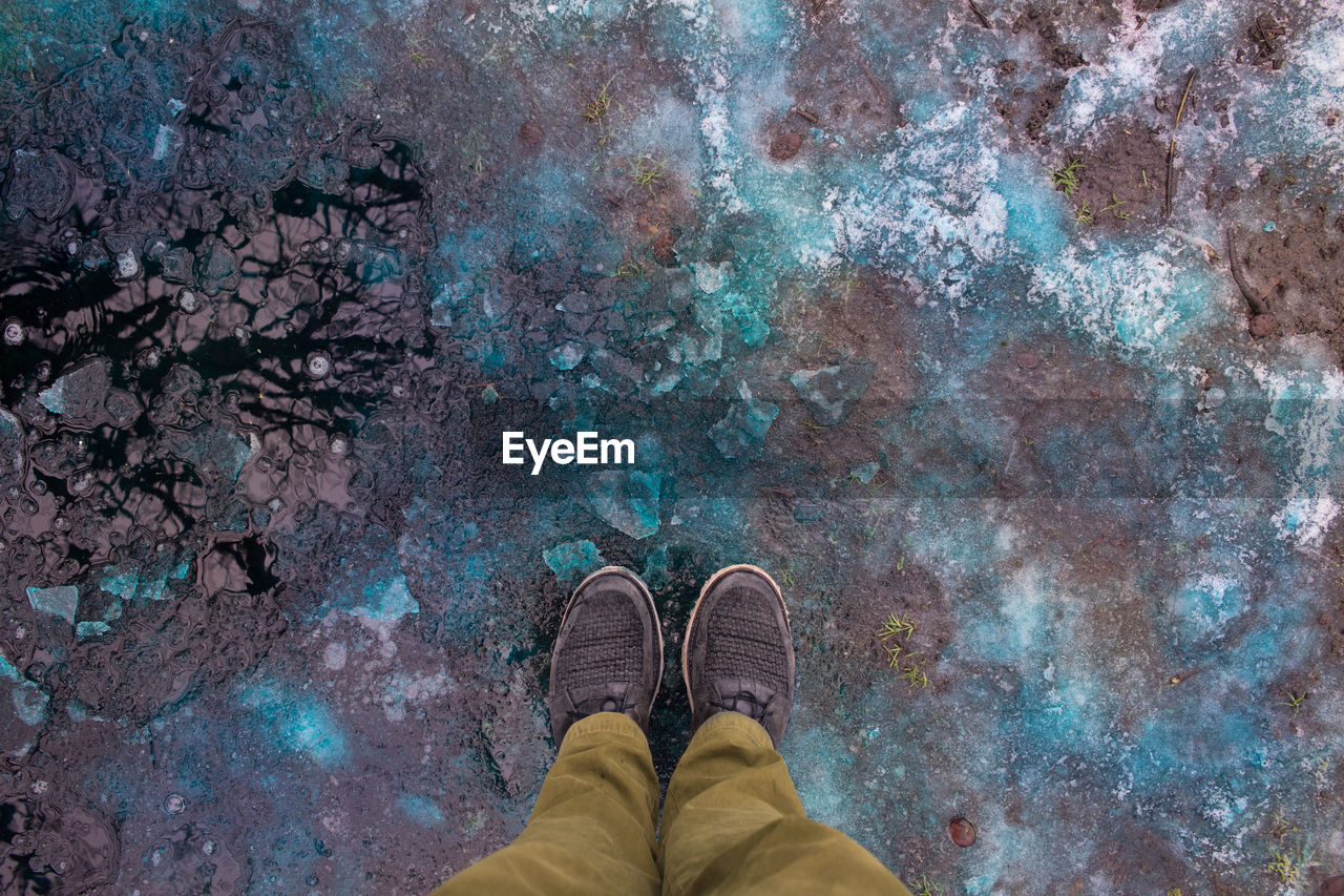 LOW SECTION OF PERSON STANDING ON TILED FLOOR