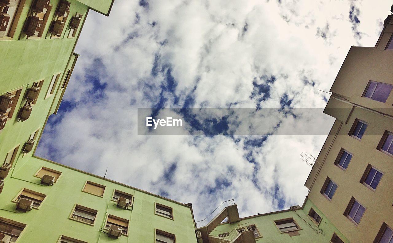 Low angle view of buildings against cloudy sky