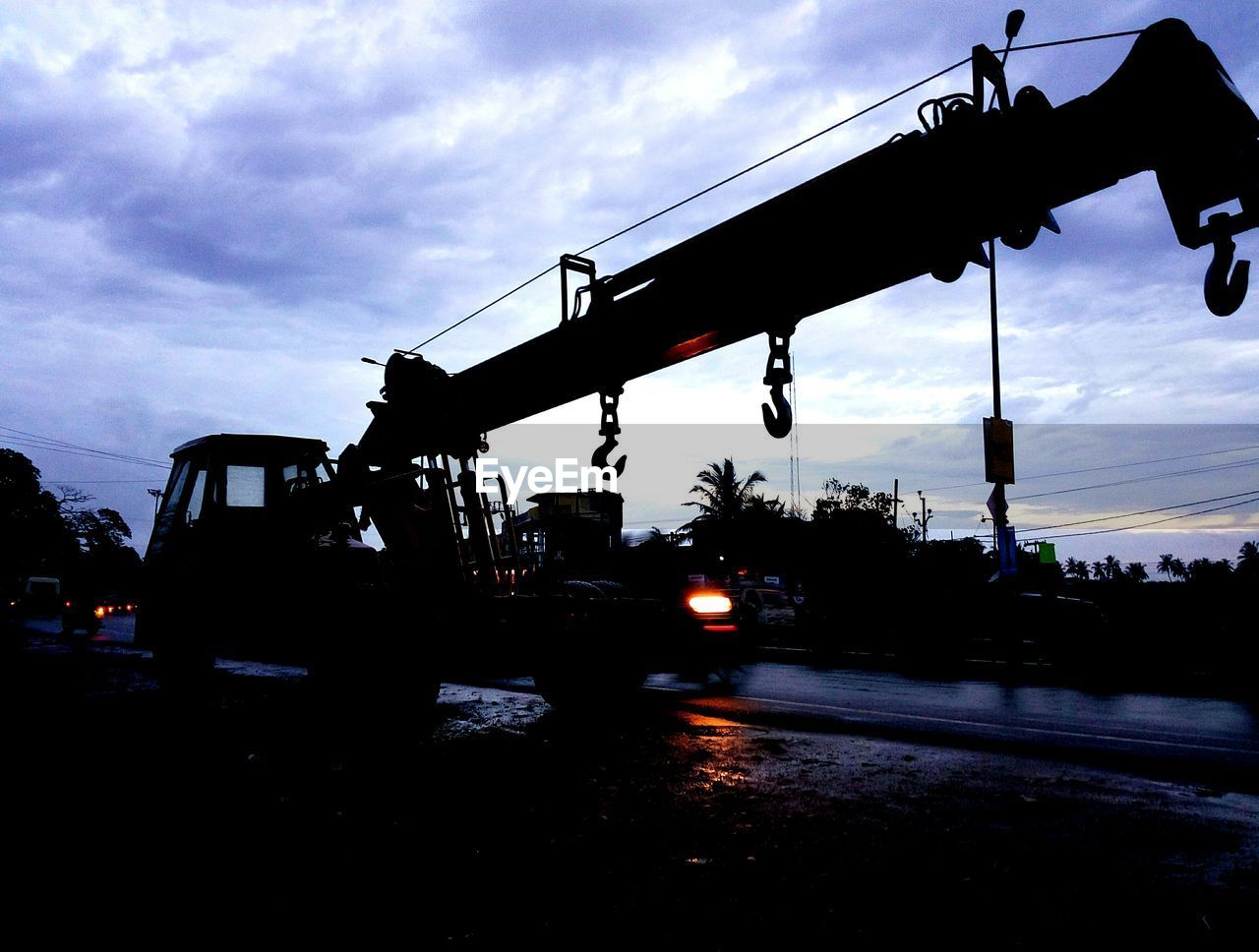 SILHOUETTE CRANES AT CONSTRUCTION SITE AGAINST SKY