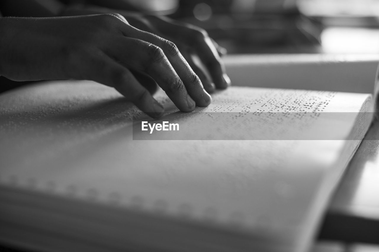 Cropped image of person reading braille