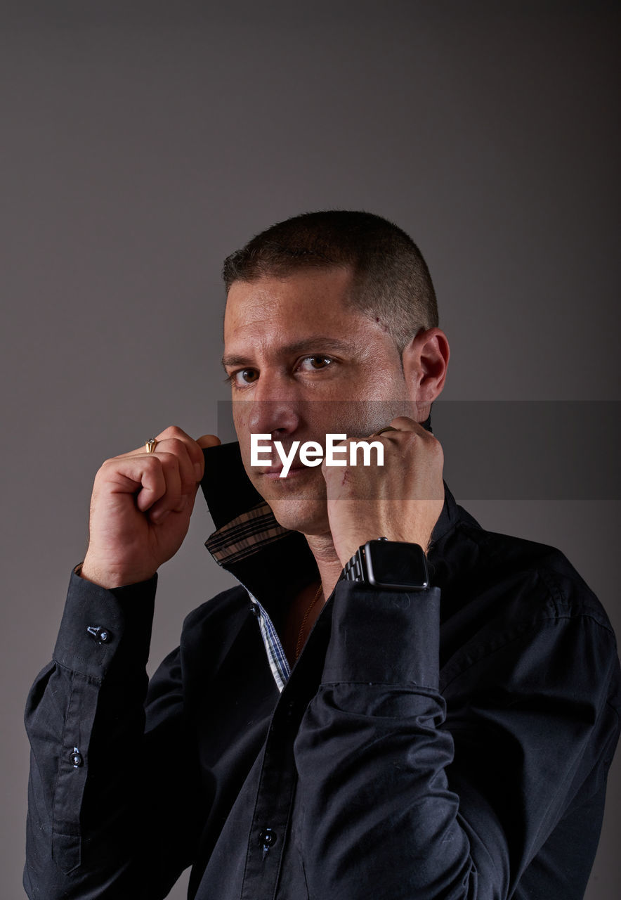 one person, adult, studio shot, men, portrait, indoors, person, gray background, hand, waist up, black, serious, business, gray, communication, jacket, emotion, mature adult, looking at camera, clothing, looking, shaved head, formal wear, businessman, headshot