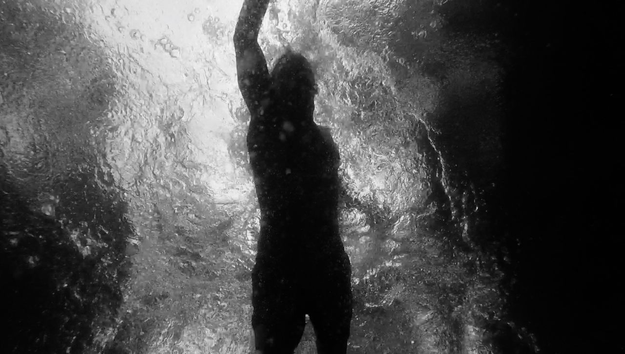 Silhouette of person swimming in sea