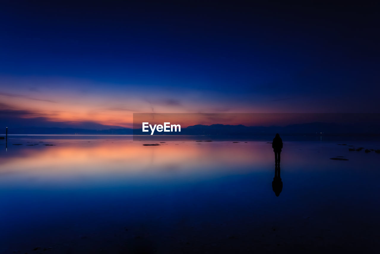 Scenic view of lake against sky at sunset