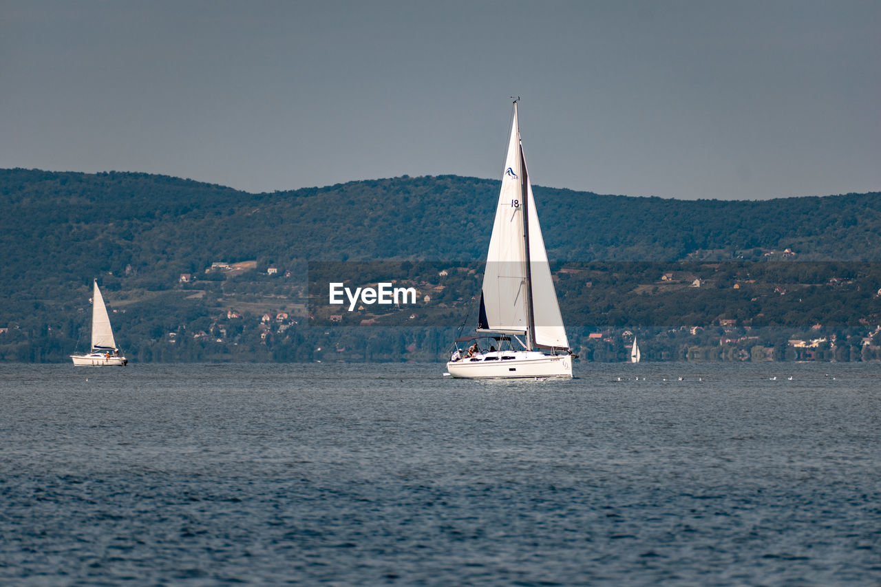 Sailboat sailing on sea against sky