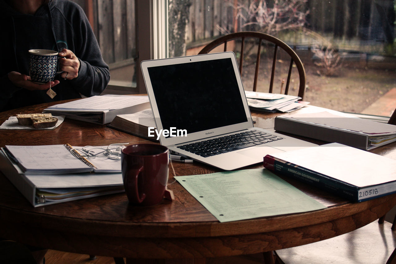 MIDSECTION OF MAN USING LAPTOP